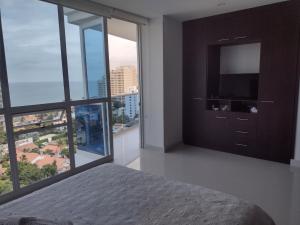 um quarto com uma cama e uma grande janela em APARTAMENTO BELLO HORIZONTE em Santa Marta
