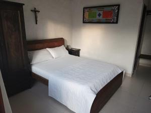 a bedroom with a bed with a cross on the wall at Hotel Villa Maritza in Melgar