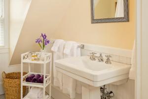 a bathroom with a sink and a mirror and towels at The Lady Mary Inn in North Berwick