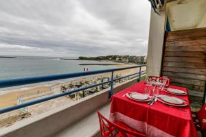una mesa en un balcón con vistas a la playa en Studio la Pergola, en San Juan de Luz
