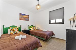 a bedroom with two beds with white towels on them at Holiday in Lanzarote! in Tías