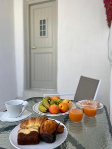 a table with two plates of food and two cups of orange juice at Lamar Cave house in Emporio Santorini