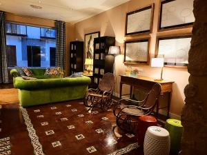 a living room with a green couch and chairs at Hotel Carmen Boutique in Baeza