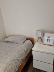 um quarto com uma cama e uma cómoda com uma fotografia em Maison Noordburg Veurne em Veurne