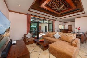 a living room with a couch and a table at Villa Hoata| Luxury 2BR villa in the Baan Bua Estate | Nai Harn beach in Nai Harn Beach