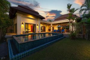 a house with a swimming pool in front of it at Villa Hoata| Luxury 2BR villa in the Baan Bua Estate | Nai Harn beach in Nai Harn Beach