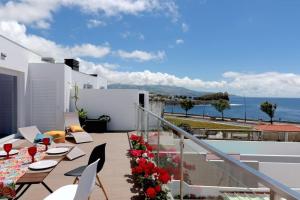 balkon ze stołem i krzesłami oraz oceanem w obiekcie Consuls Ocean View w mieście Ponta Delgada