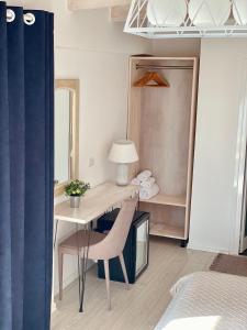 a bedroom with a desk with a chair and a mirror at Ionian Terrace in Himare
