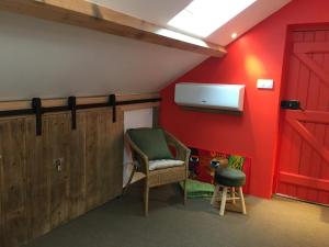 a room with a chair and a red wall at Ô Lit' Chi in Hermillon