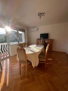 a dining room with a table and chairs and a television at Villa ''M&A'' in Sarajevo