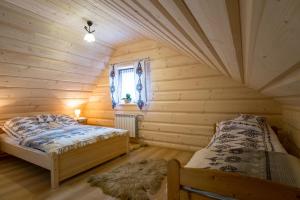 1 dormitorio con 2 camas en una habitación de madera en Apartamenty u Gabi, en Poronin