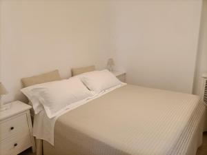 un lit avec des draps blancs et des oreillers dans une chambre dans l'établissement Case Gallina, à Avola