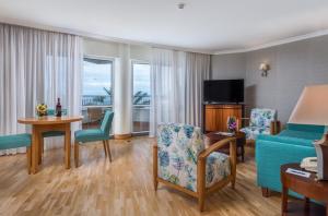 uma sala de estar com um sofá, uma mesa e cadeiras em Pestana Grand Ocean Resort Hotel no Funchal