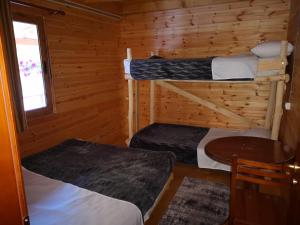 KomanにあるRiverside Komani Lakeのキャビン内の二段ベッド2台が備わる客室です。