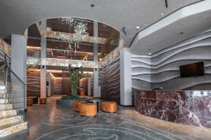 a lobby with a staircase and a potted plant at Kravt Kazan Airport Hotel in Bol'shiye Kabany