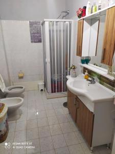 bagno con doccia, 2 lavandini e servizi igienici di La casa di Anna a Grisolia