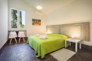 a bedroom with a green bed and two chairs at Villa Brancolin in Garda