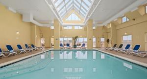 a large swimming pool with chairs and a skylight at Bonita Beach Hotel in Ocean City