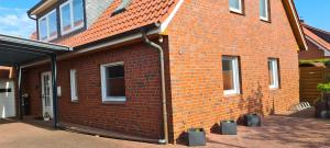 ein rotes Backsteinhaus mit einem roten Dach in der Unterkunft Erholung Pur bei Familie Peters in Fehmarn