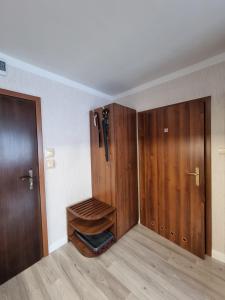 una habitación vacía con armarios de madera y una puerta en Apartament blisko morza Carmen en Kołobrzeg
