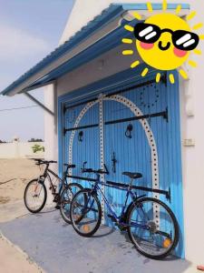 Nouveau Bungalow Djerba في حومة السوق: اثنين من الدراجات متوقفة أمام مبنى مع علامة الشمس