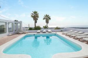 a swimming pool with chaise lounge chairs and a pool at Casa blanca in Tías