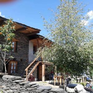 a log cabin with a staircase in front of it at Hotel Omalo2005 in Omalo