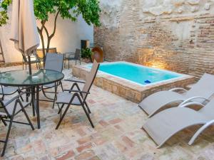 a patio with a table and chairs and a pool at Belvilla by OYO Casa Palacio de la Carrera in Fuentes de Andalucía