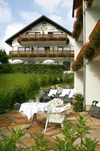 a patio with a table and chairs in front of a building at LandKomfort Hotel Elsenmann Garni in Willingen