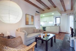 
a living room filled with furniture and a table at Inside Barcelona Apartments Esparteria in Barcelona

