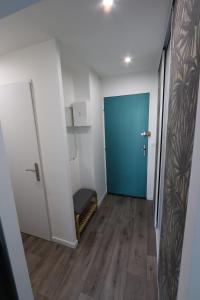 um corredor com uma porta azul e uma cadeira em Studio tout confort - Climatisation, parking, wifi em Gréoux-les-Bains