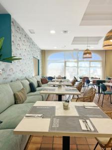 un ristorante con tavoli e divani in una stanza di Soho Boutique Puerto a El Puerto de Santa María