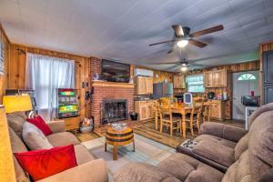 uma sala de estar com sofás e uma mesa e uma cozinha em Cozy Kentucky Cabin with Sunroom, Yard and Views! em Cub Run