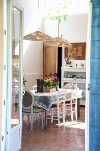 a dining room with a white table and chairs at Domaine de Montbarri in La Tour-sur-Orb