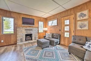 a living room with a couch and a fireplace at Cozy Petoskey Area Retreat on Burt Lake Access! 