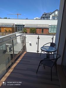 einen Balkon mit einem Tisch und einem Stuhl auf einem Gebäude in der Unterkunft Flamingo 20 in Misdroy