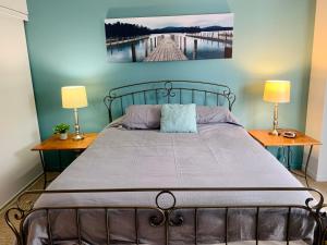 ein Schlafzimmer mit einem Bett mit zwei Lampen und einem Gemälde an der Wand in der Unterkunft Condo Club Azur Plage Memphremagog in Magog-Orford