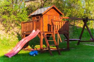 un parque infantil con tobogán y una casa de juegos en Apartamenty na Jurze, en Siamoszyce