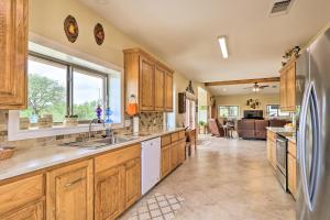 Una cocina con gabinetes de madera y un refrigerador de acero inoxidable. en Bertram Ranch Property with Patio and Gas Grill!, en Bertram