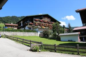 a house with a fence in front of it at Hotel Sonnleiten in Reit im Winkl