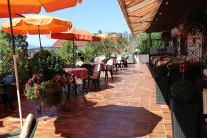 an outdoor patio with tables and chairs and umbrellas at Hotel Sonnleiten in Reit im Winkl