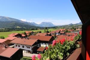 a town in the mountains with flowers in the foreground at Deva Hotel Sonnleiten in Reit im Winkl