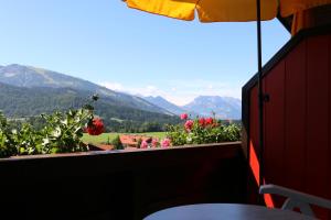 a balcony with a view of flowers and mountains at Hotel Sonnleiten in Reit im Winkl