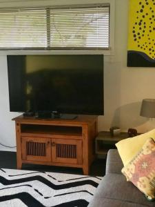 a living room with a large flat screen tv at Private Room in Pleasant Ashmore in Gold Coast