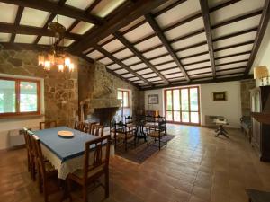 a living room with a table and chairs and a fireplace at Villa Strada dei Monti Sibillini in Montefortino