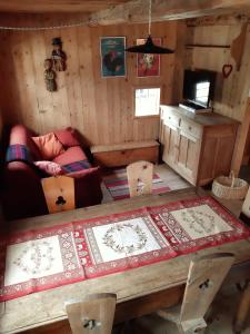 una habitación con una mesa y un sofá en una cabaña en Piccolo e accogliente rascard CIR 0060, en Champoluc