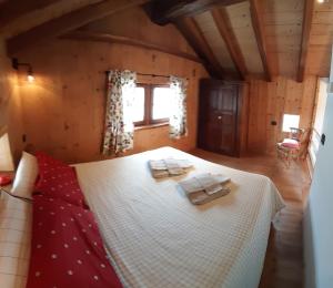 a bedroom with a bed with two towels on it at Piccolo e accogliente rascard CIR 0060 in Champoluc