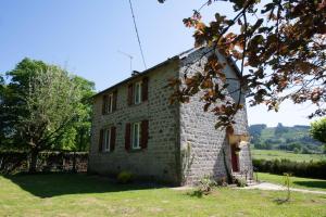 an old brick building in a field of grass at La Petite Ecole in Treignac