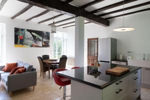 een keuken en een woonkamer met een bank en een tafel bij La Petite Ecole in Treignac