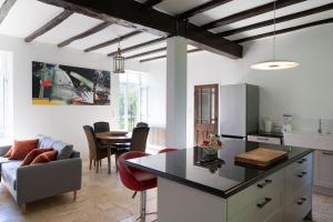 a kitchen and living room with a couch and a table at La Petite Ecole in Treignac